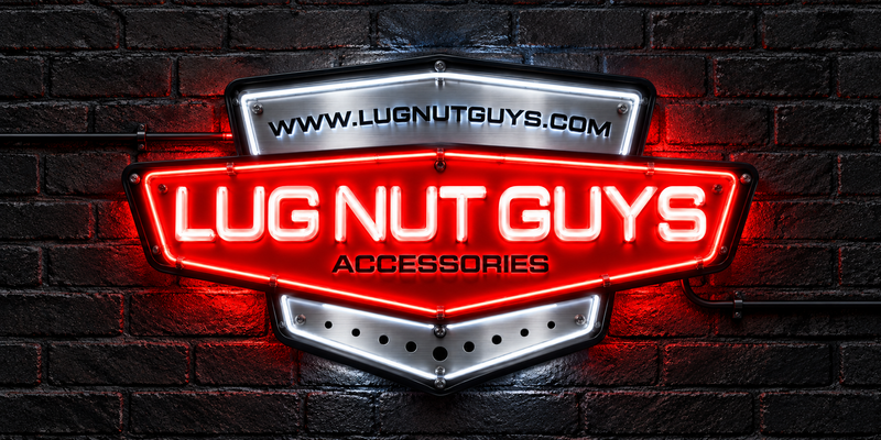 A glowing red and silver LED neon-style sign for 'Lug Nut Guys Accessories' mounted on a dark brick wall. The sign features the website 'WWW.